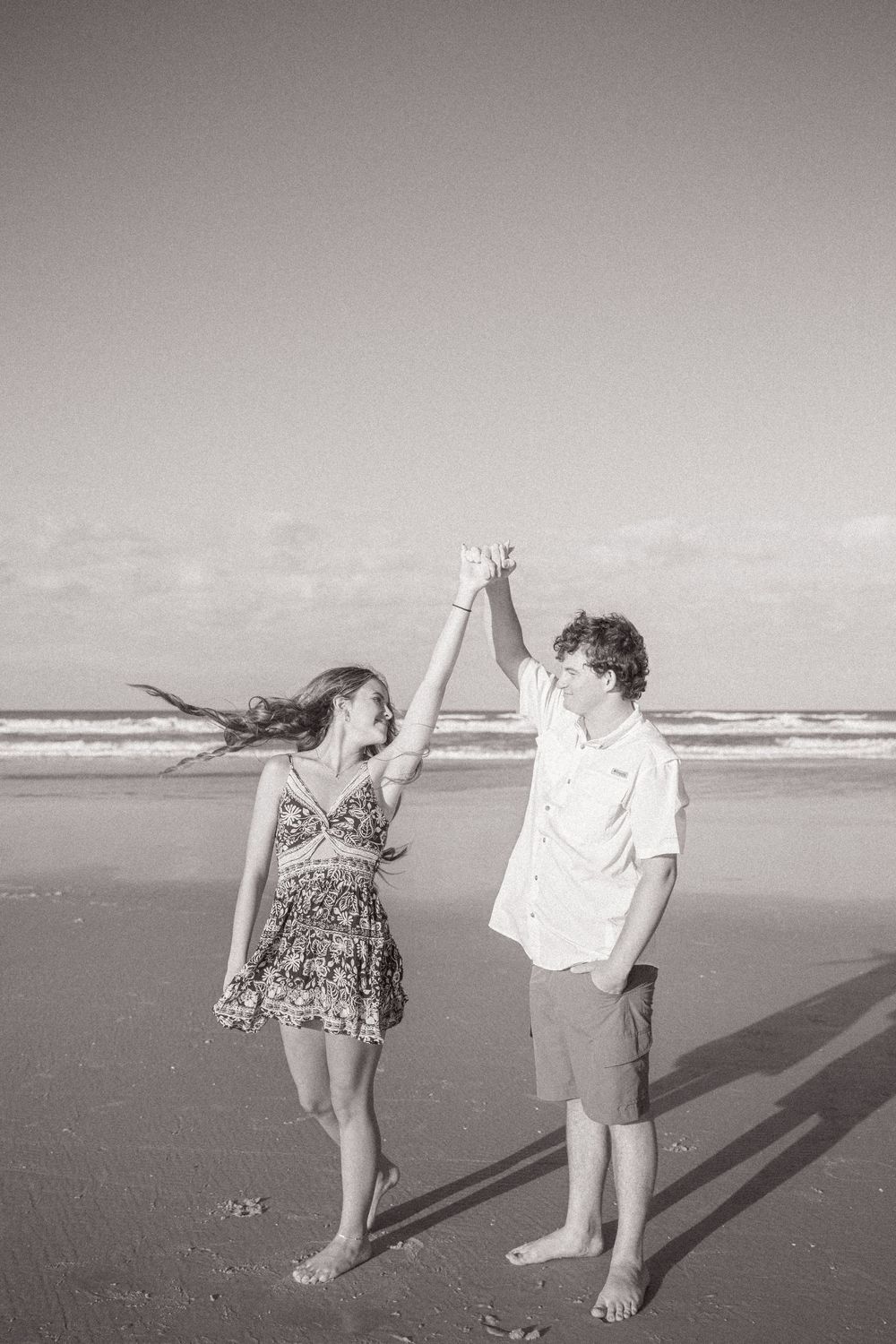 Black and white beach photos showing silhouettes dancing and playing in the sand.