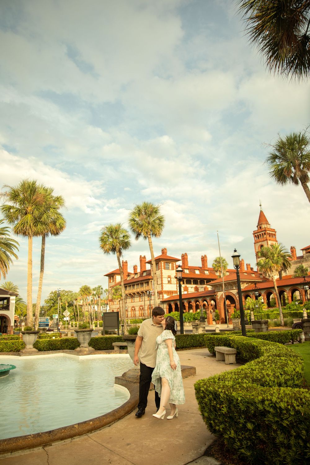 A couple strolls along a landscaped path with the historic Flagler College building in the background.
