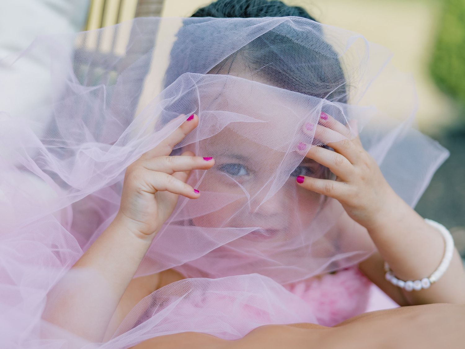 A sequence of intimate wedding photos showing a pink veil framing romantic moments between partners.