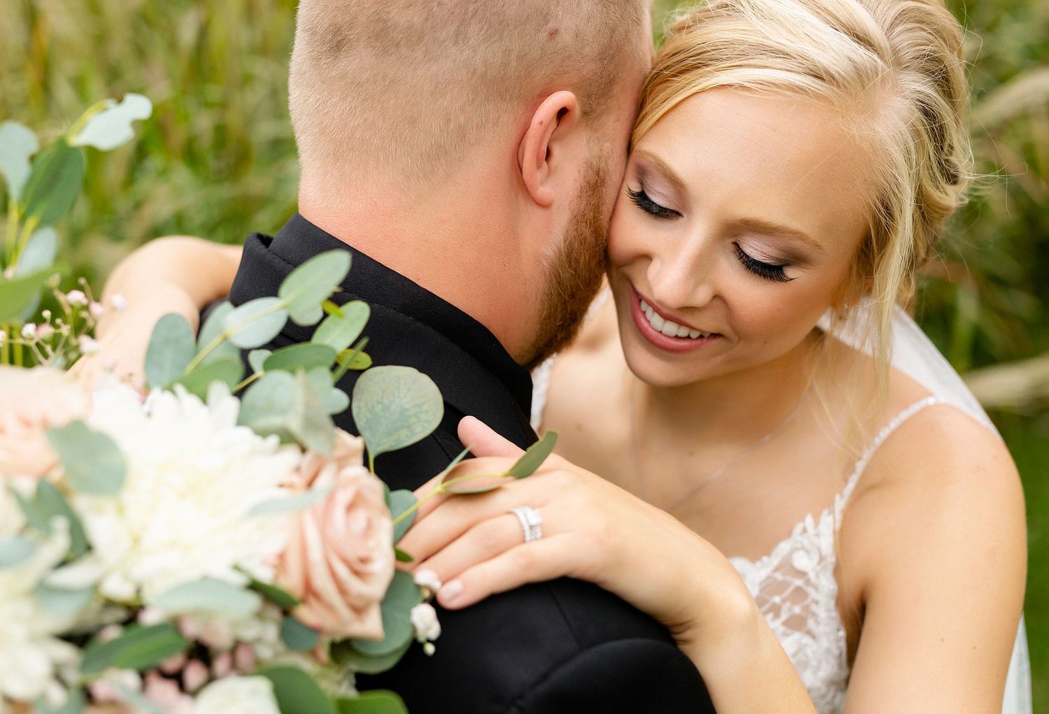 Intimate wedding moment captured with elegant floral bouquet featuring soft pink roses and eucalyptus.