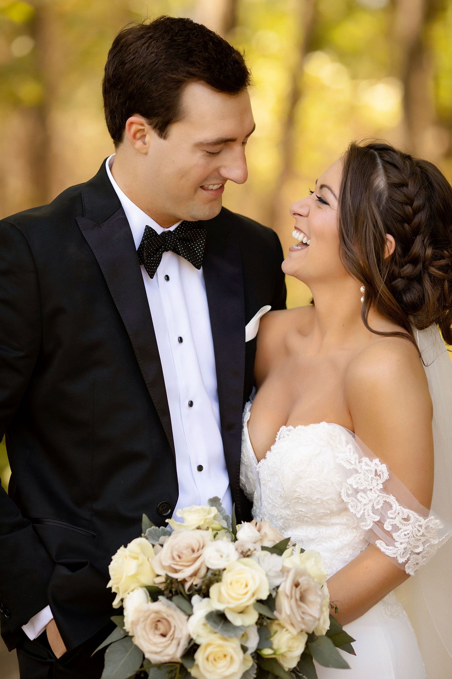 Joyful wedding portrait with cream roses bouquet in autumn setting.