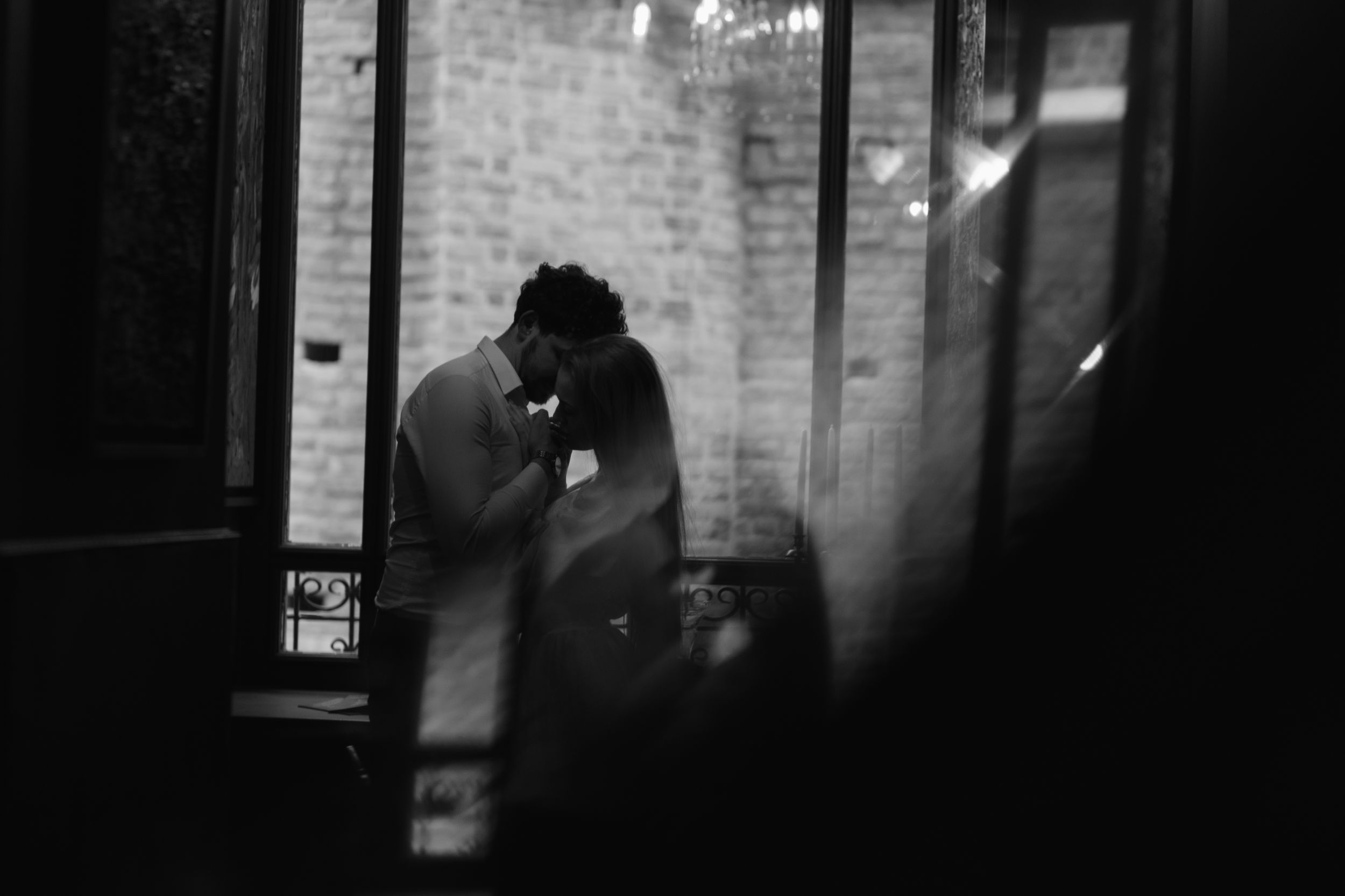 A grainy black and white photograph shows a silhouetted figure standing in a doorway at night.