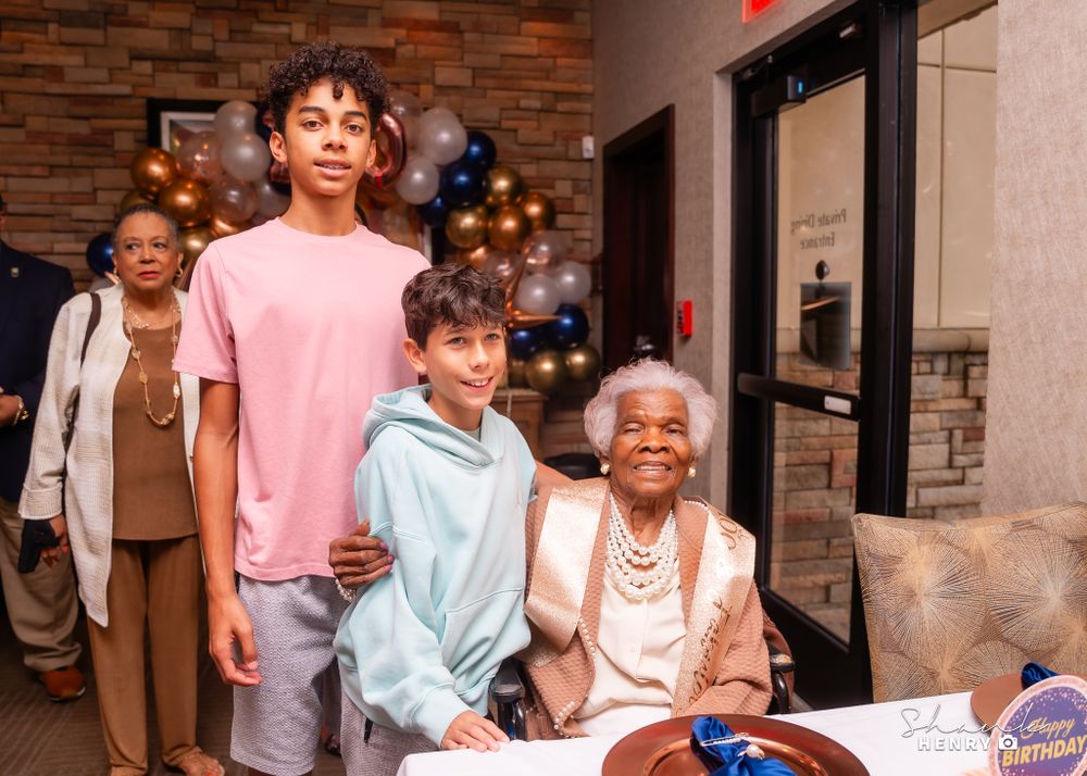 Multi-generational family gathering at a restaurant with brick walls and warm lighting.