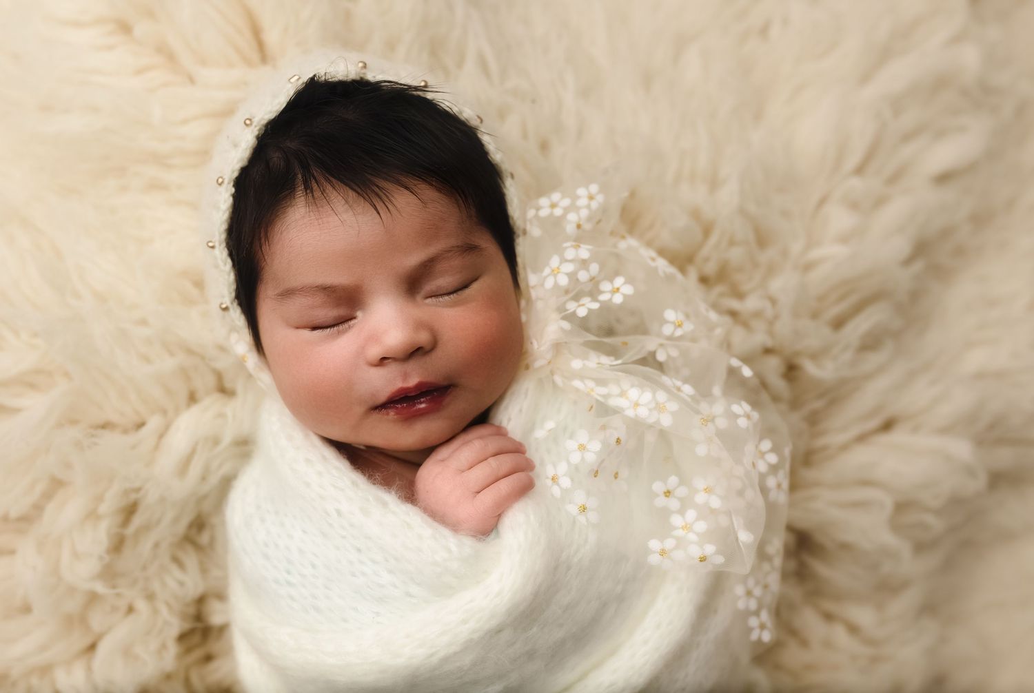 Charlottesville photographer, maternity, family, baby, newborn girl sleeping in floral hat and soft wrap on a wool rug.