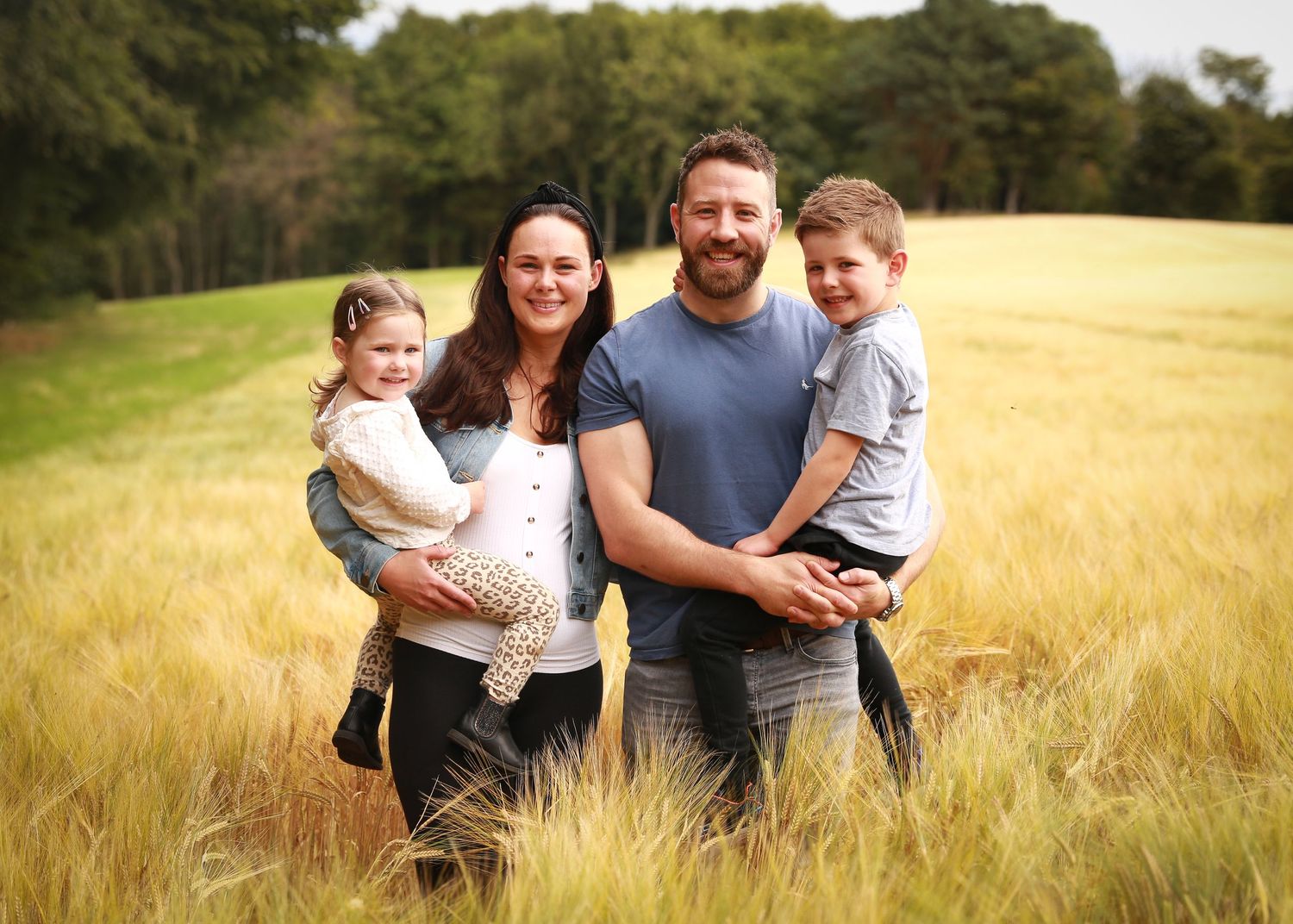 A joyful family enjoying a moment together in the tranquil surroundings of Dunnottar Woods, capturing the beauty of nature and connection