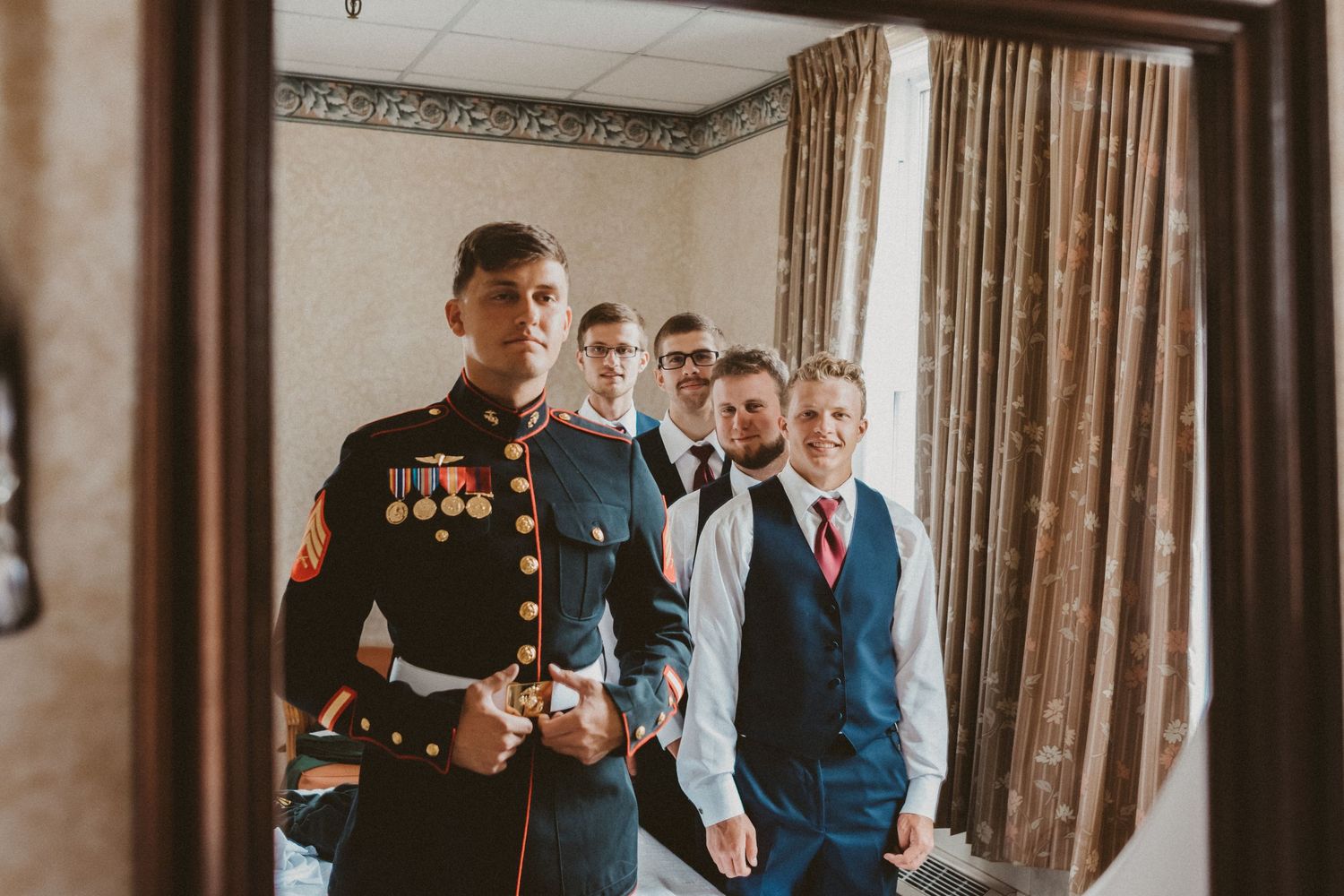Groomsmen pose together in formal attire before wedding ceremony.
