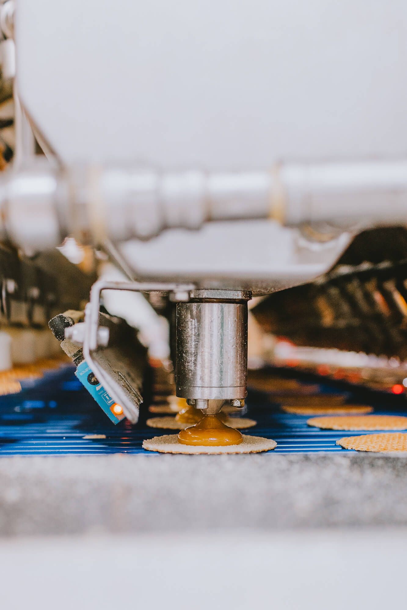 Macro shot of industrial sewing machine needle stitching blue fabric at high speed.