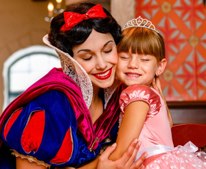 Theme park character meet and greet moment with guest in princess attire.