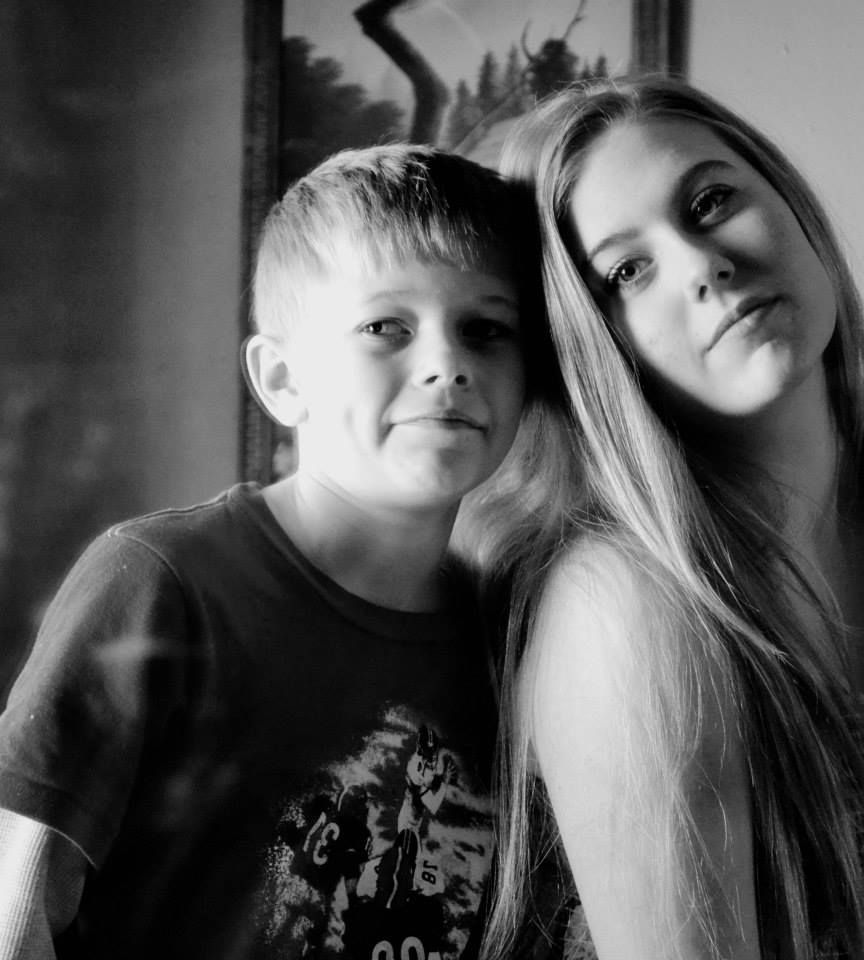 A black and white portrait of two people posing together with soft lighting and intimate composition.