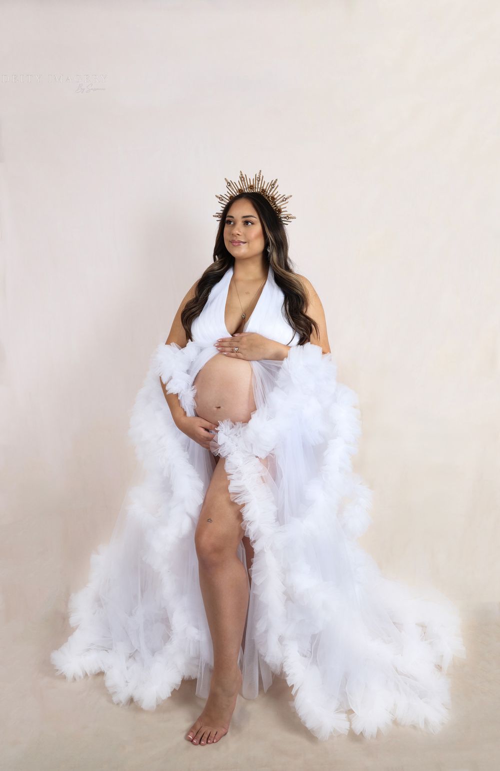Ethereal maternity photos with flowing white fabric against neutral backdrop.