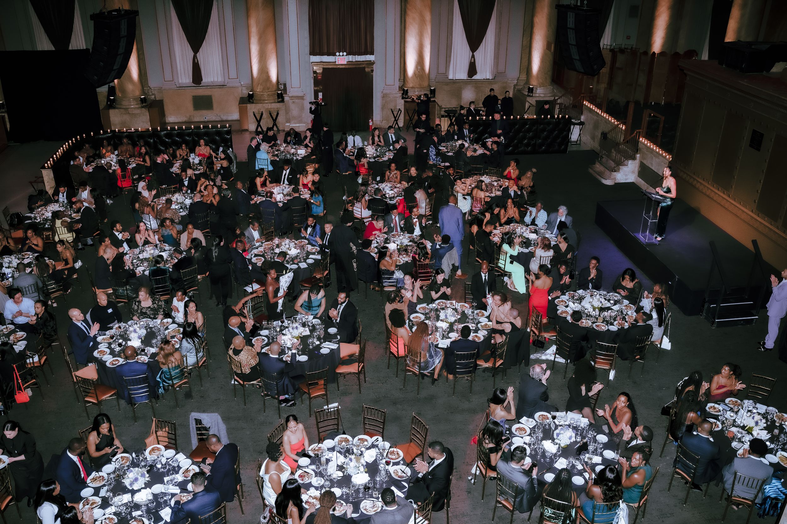 Aerial view of a formal banquet hall with round tables and dining guests.