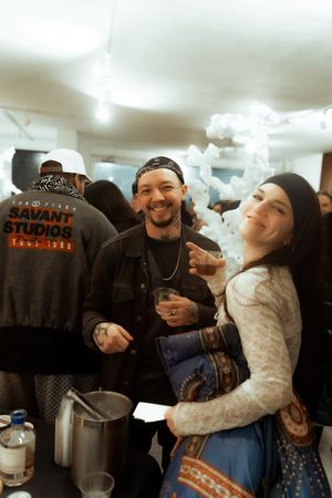 Friends enjoying drinks and laughter together in a cozy indoor setting with ambient lighting.