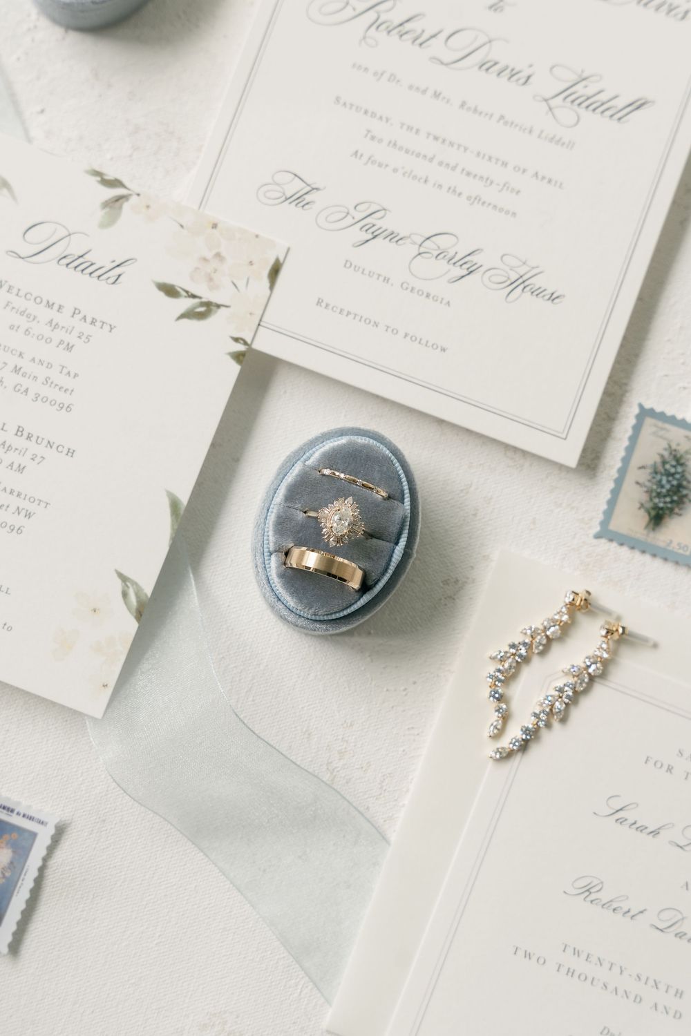 Elegant wedding invitation suite with engagement ring in blue velvet box.