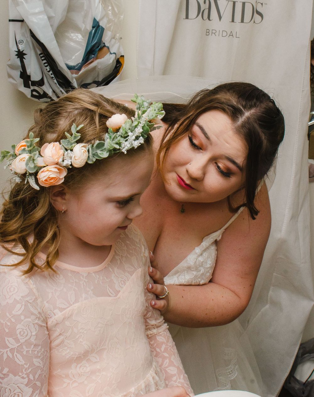 A tender moment shared between two people in a bridal shop setting.