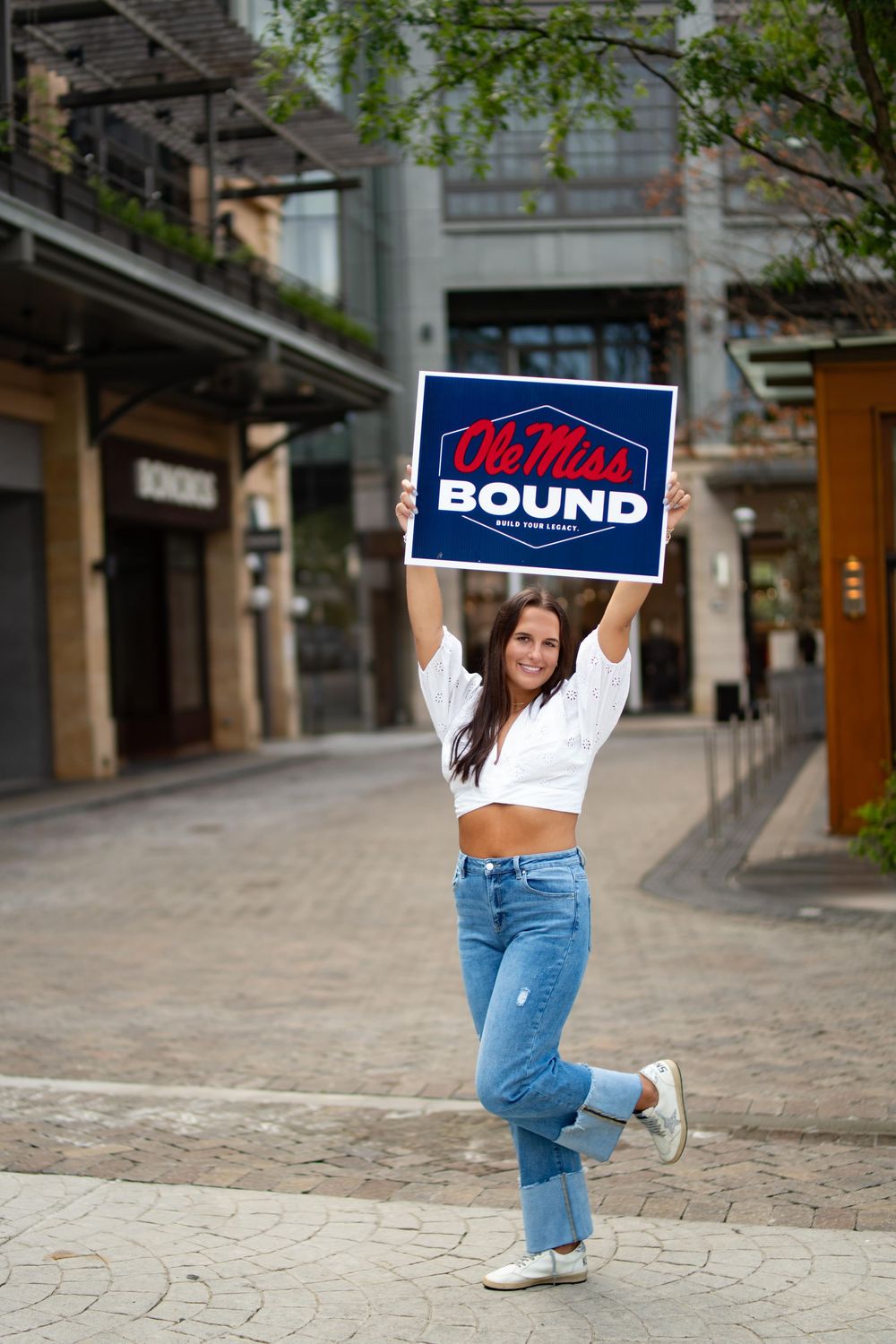 High school senior at the Atlanta History Center for senior photos holding an Ole Miss sign