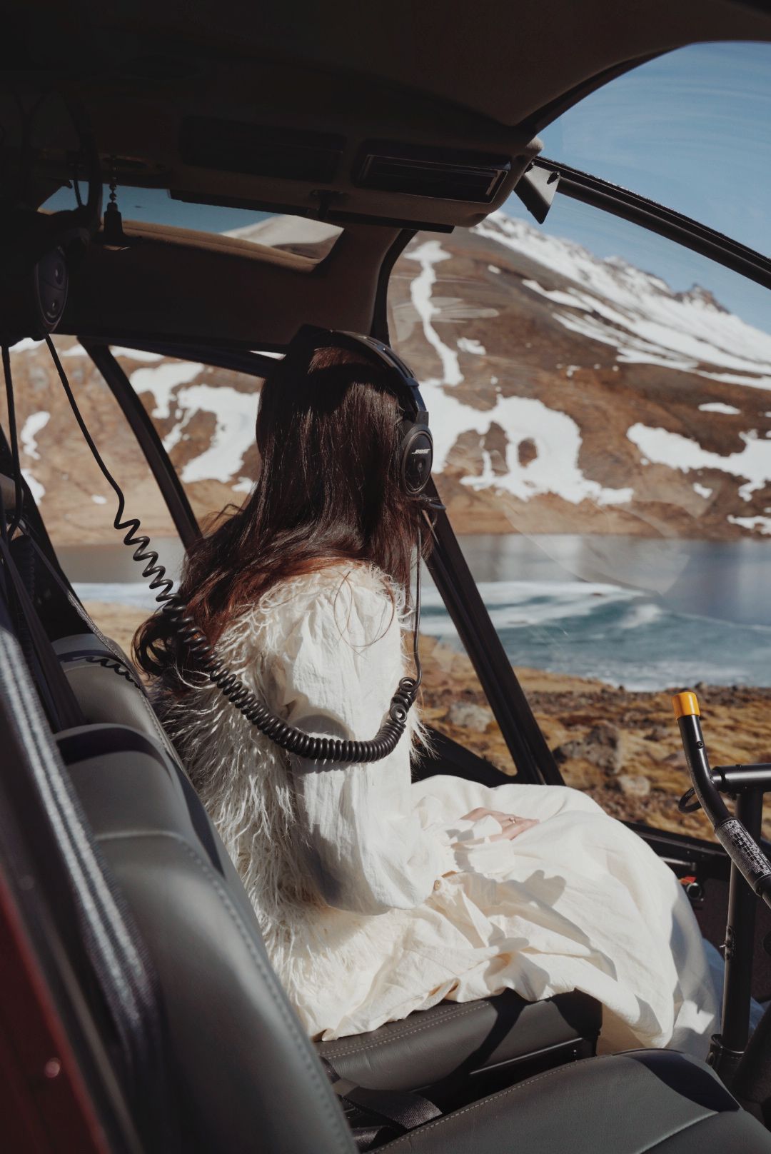 Interior view of a helicopter with snowy mountain landscape visible through windows.
