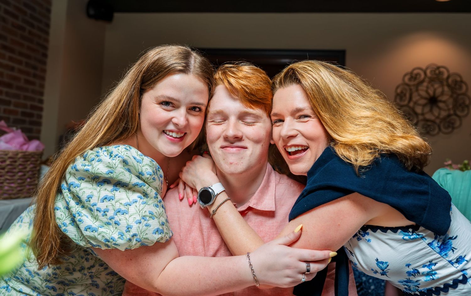 Group celebrating together in joyful embrace at indoor gathering.