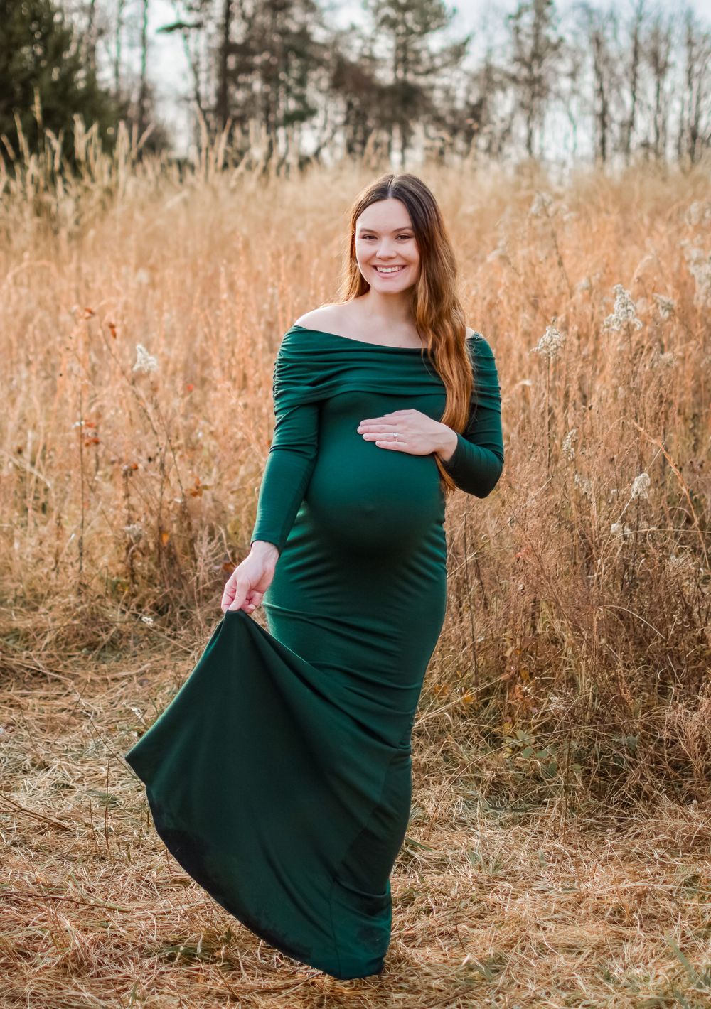 lady posed for maternity session in a grass field