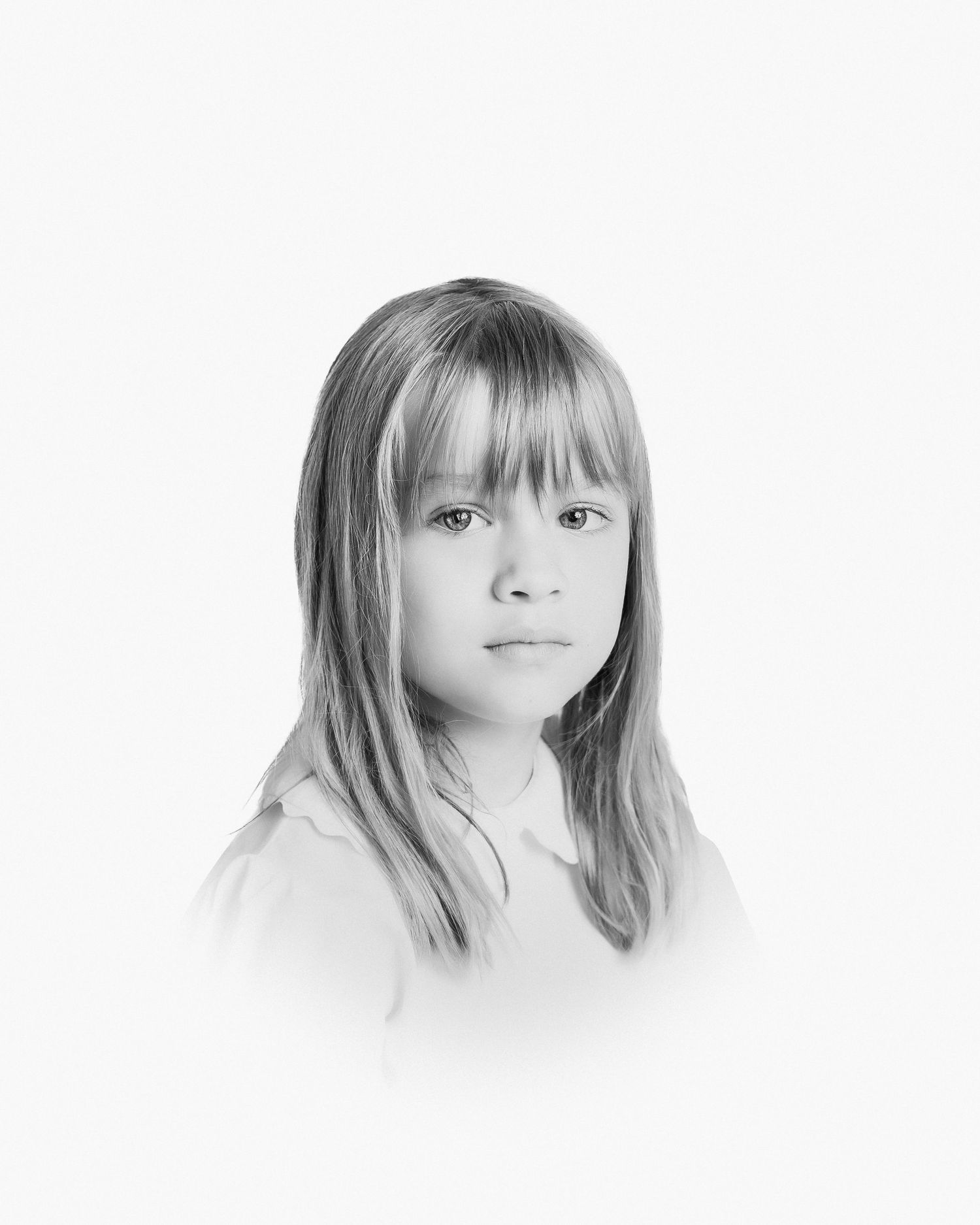 Black and white portrait of a young child with straight bangs and shoulder length hair wearing white.