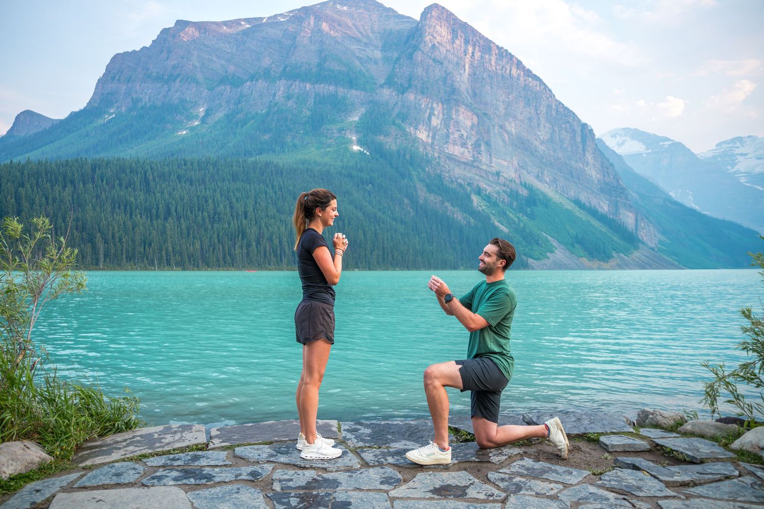 Surprise proposal moment at Lake Louise with turquoise waters and a mountain backdrop in Summer season in Banff National Park.