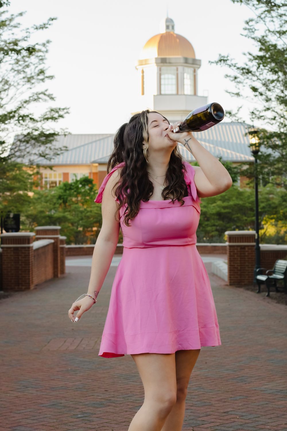 college graduate with bottle of champagne