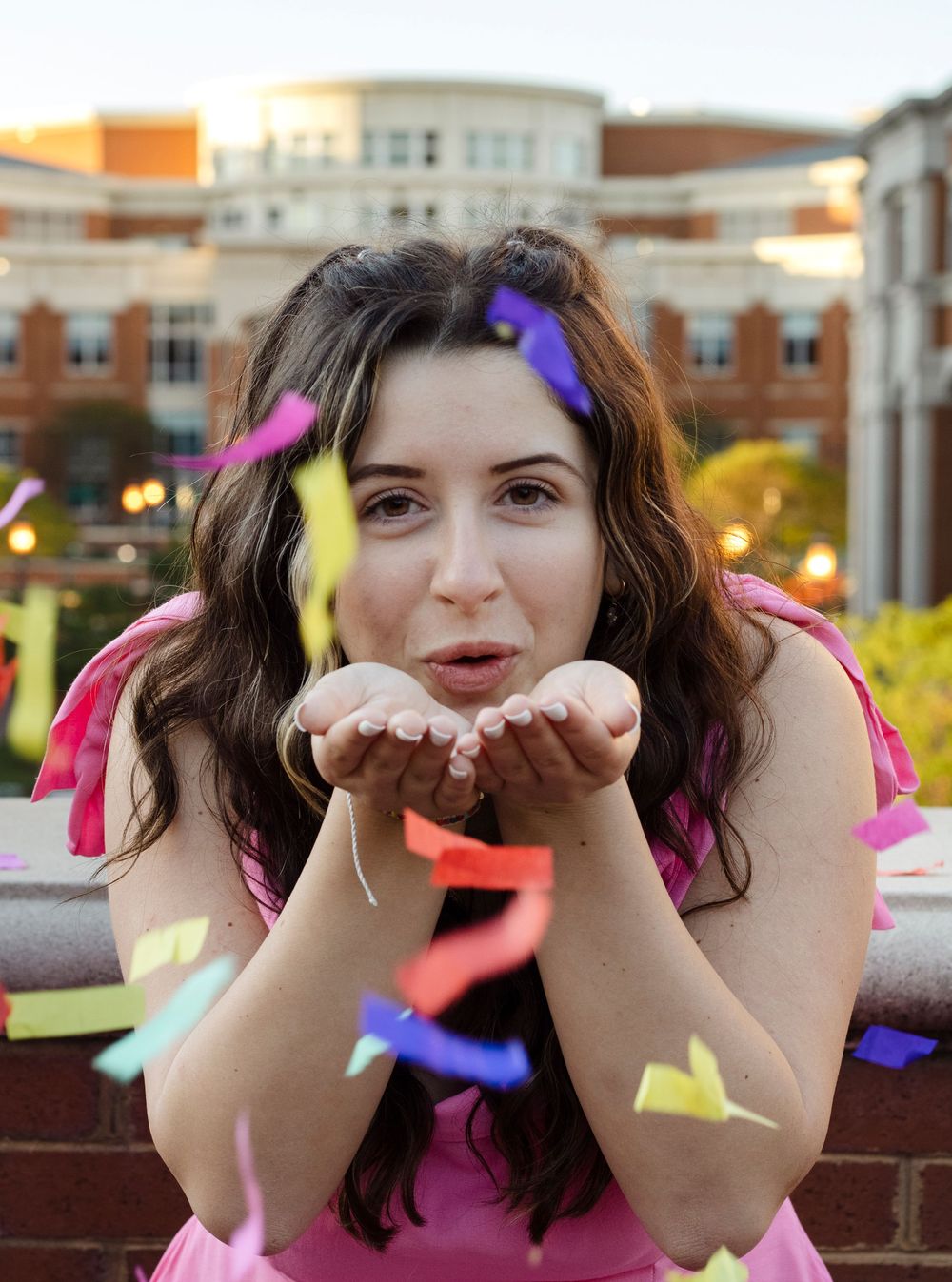 College graduate blowing confetti