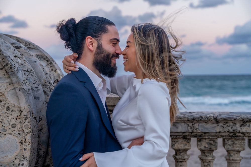Romantic seaside moment with stone balustrade and ocean waves in background.