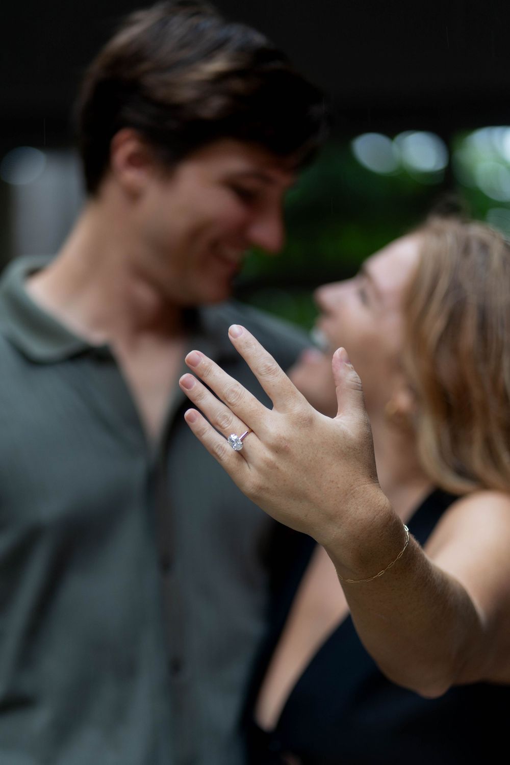 Woman showing off her engagement ring while smiling with her partner at The Kampong, Miami.