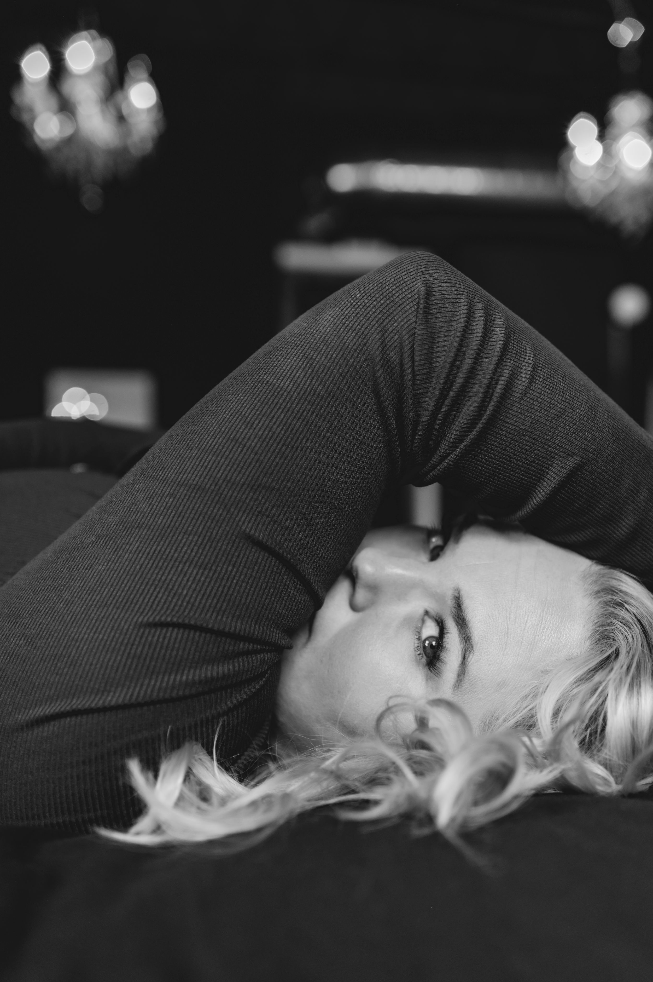 A black and white artistic portrait sequence showing a person reclining with dramatic lighting and shadows.