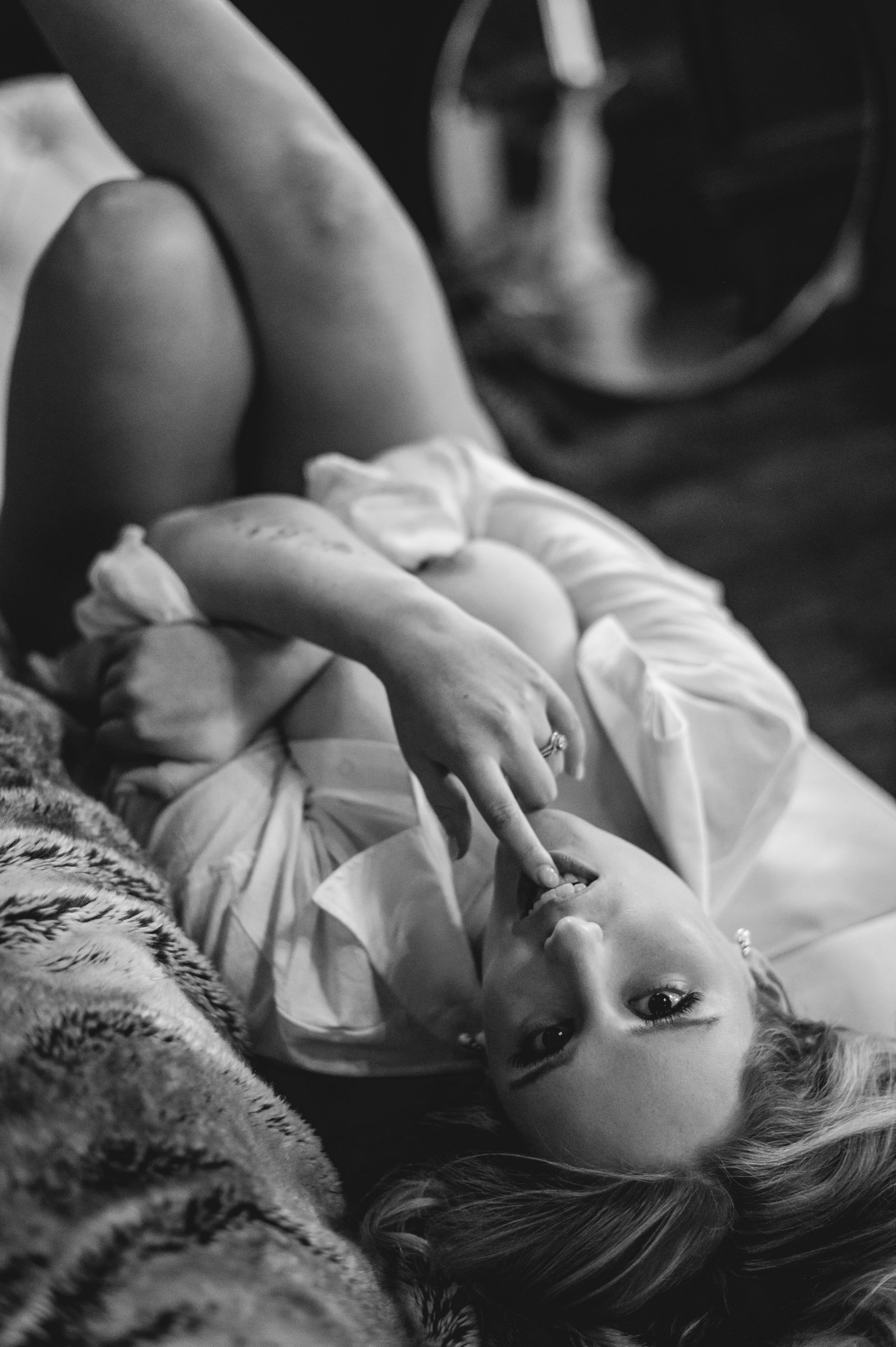 A black and white artistic portrait series showing a person lying down in soft, ethereal lighting.