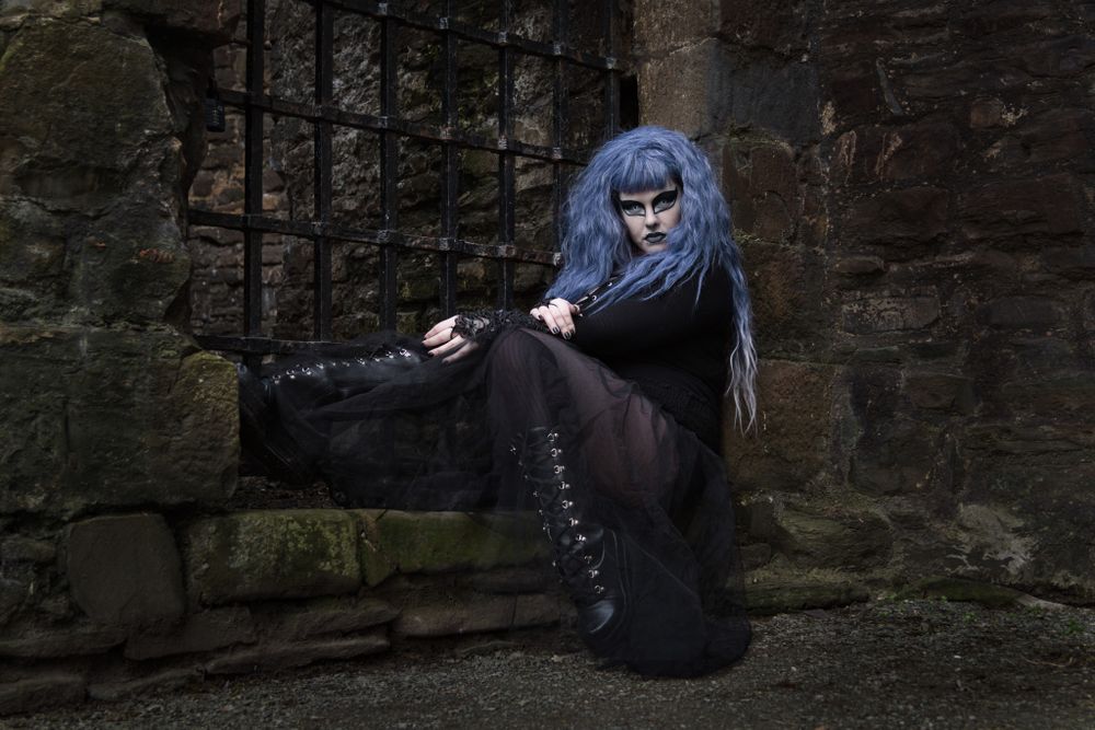 A dramatic portrait of a goth lady posing by Conwy Town Walls. Conwy Portrait Photographer