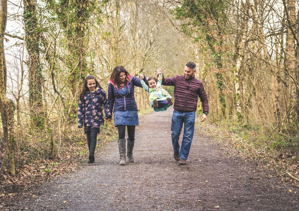 A family portrait while walking along a woodland path. Gwynedd Portrait Photographer.