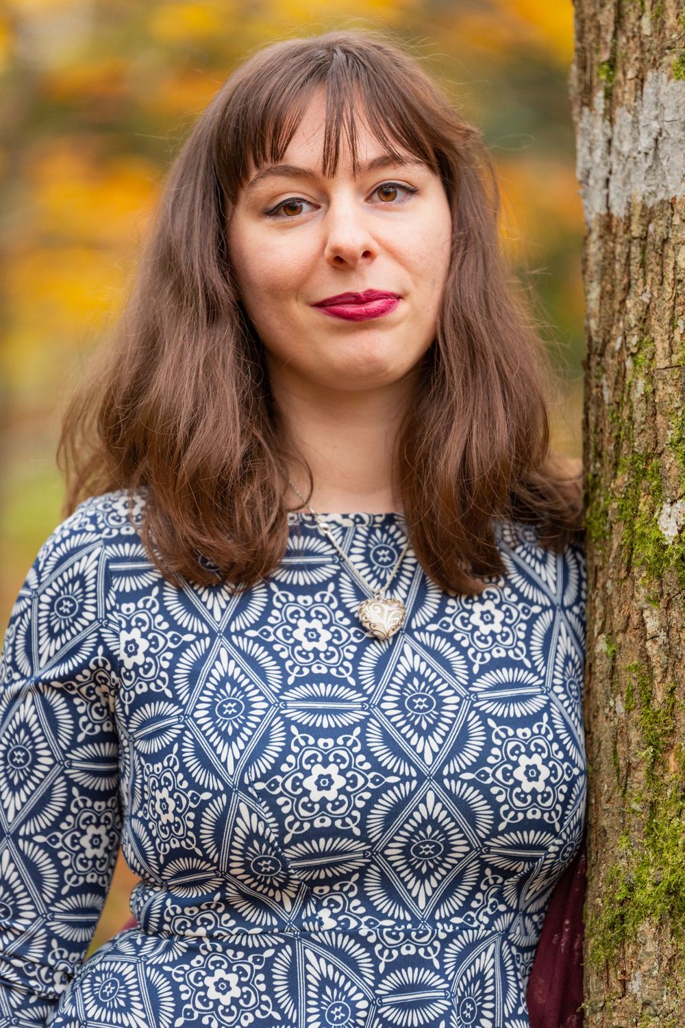 A portrait of a brunette lady in a blue top, in a woodland in autumn. North Wales Portrait Photography