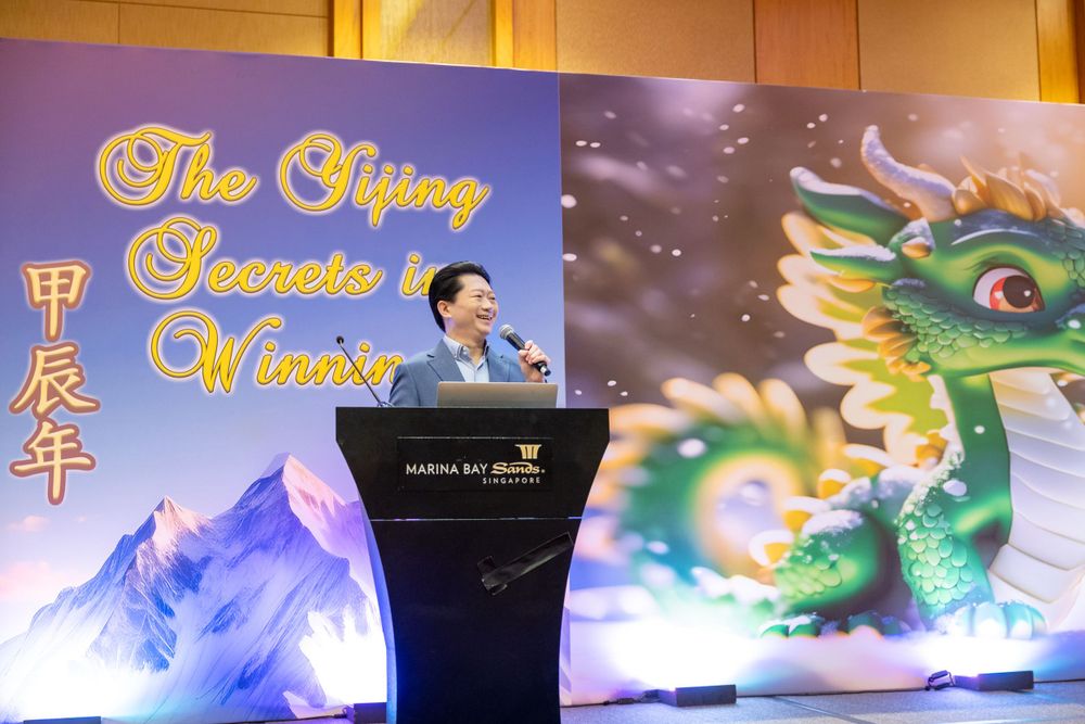 Event stage setup with Chinese dragon artwork and typography against blue backdrop.
