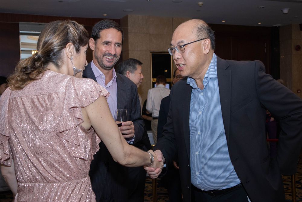 Professional networking event showing people engaged in conversation at an upscale venue.