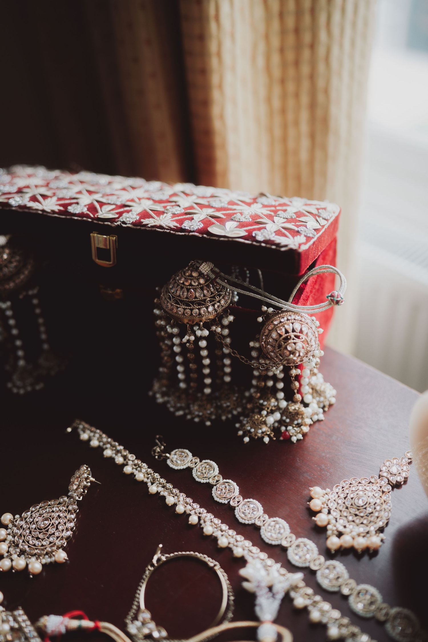 Luxurious Indian jewelry collection with pearl details displayed next to a decorative box.