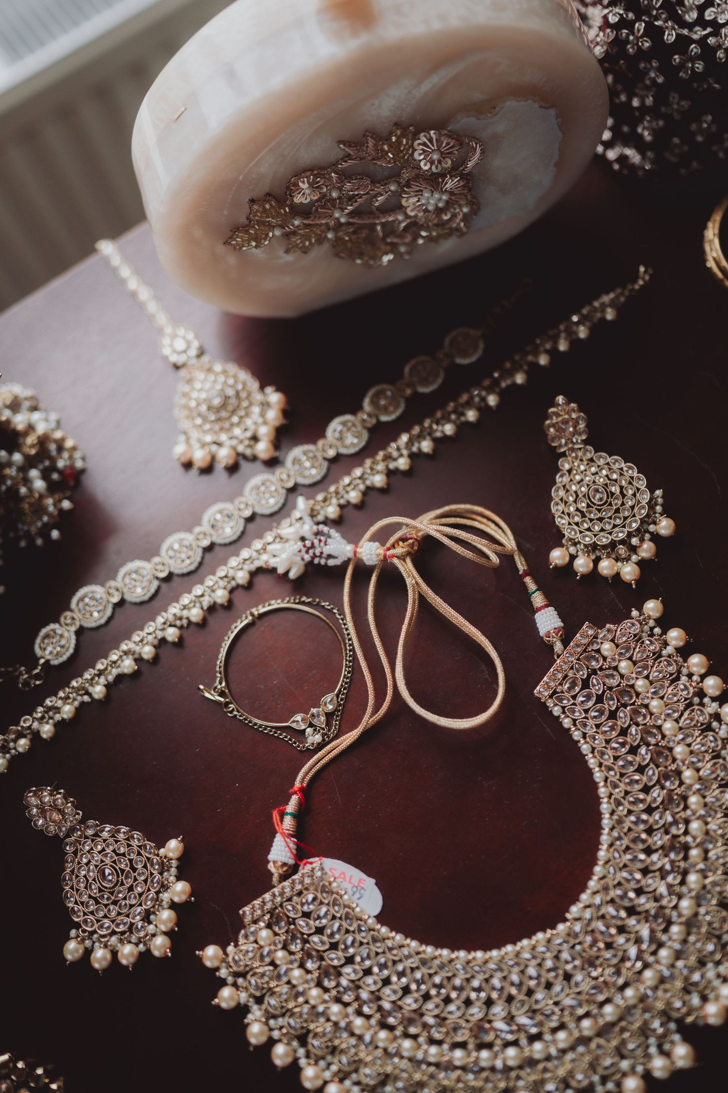 Intricate silver statement necklace and matching jewelry pieces displayed on dark wood.