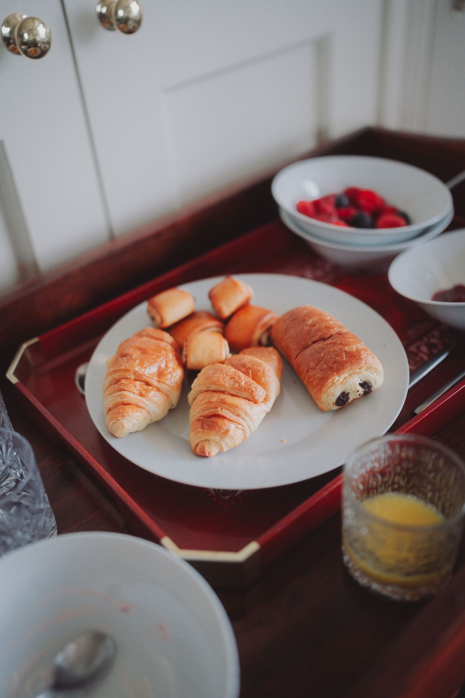 Fresh croissants and pastries served on white plates for breakfast.