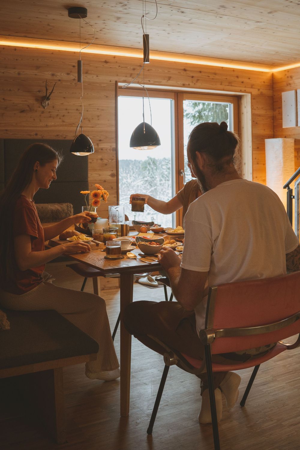 Cozy dining scene in a wood-paneled cabin with warm lighting.
