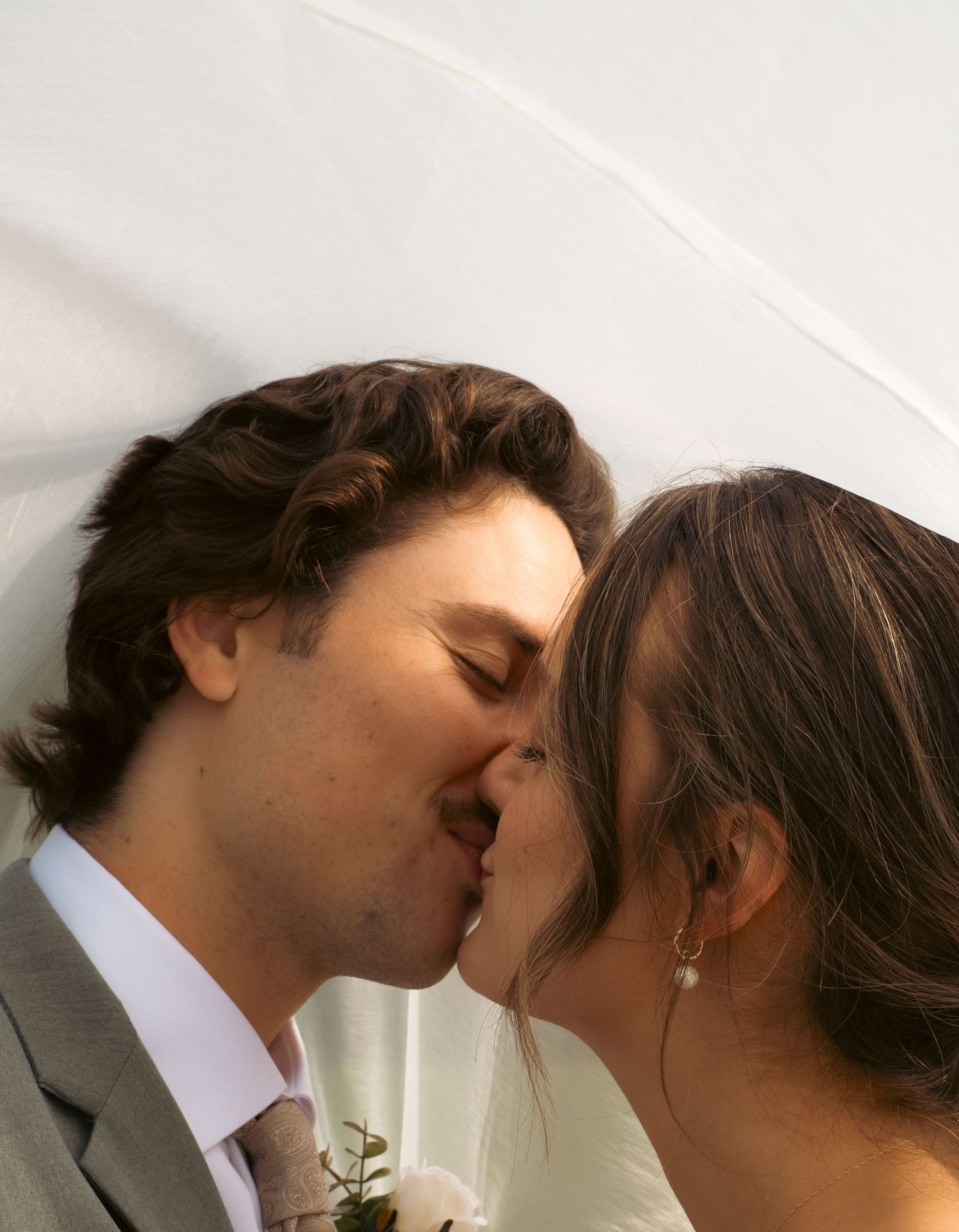 A tender wedding day kiss between newlyweds.