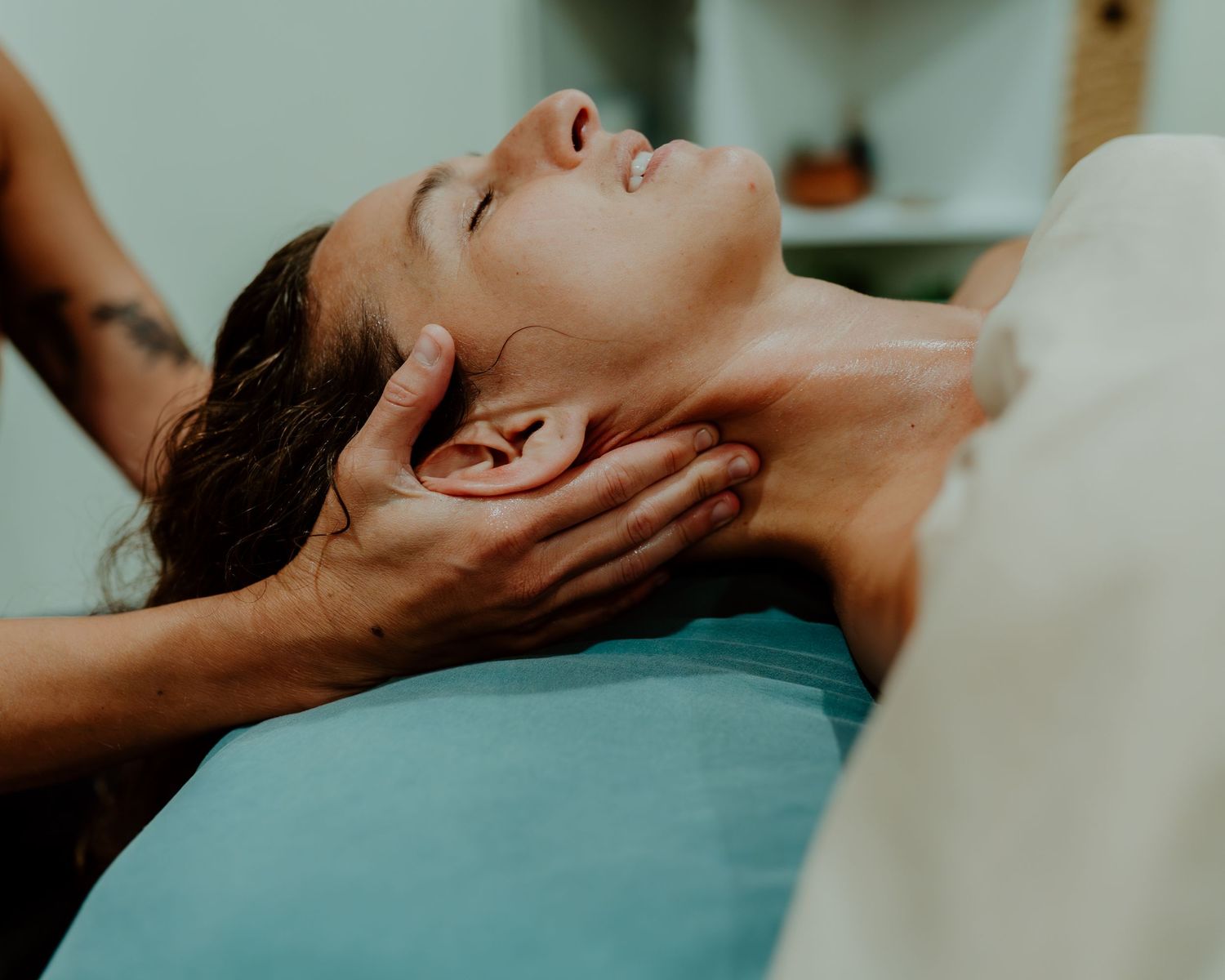 Person receiving a relaxing facial massage treatment on a massage table.