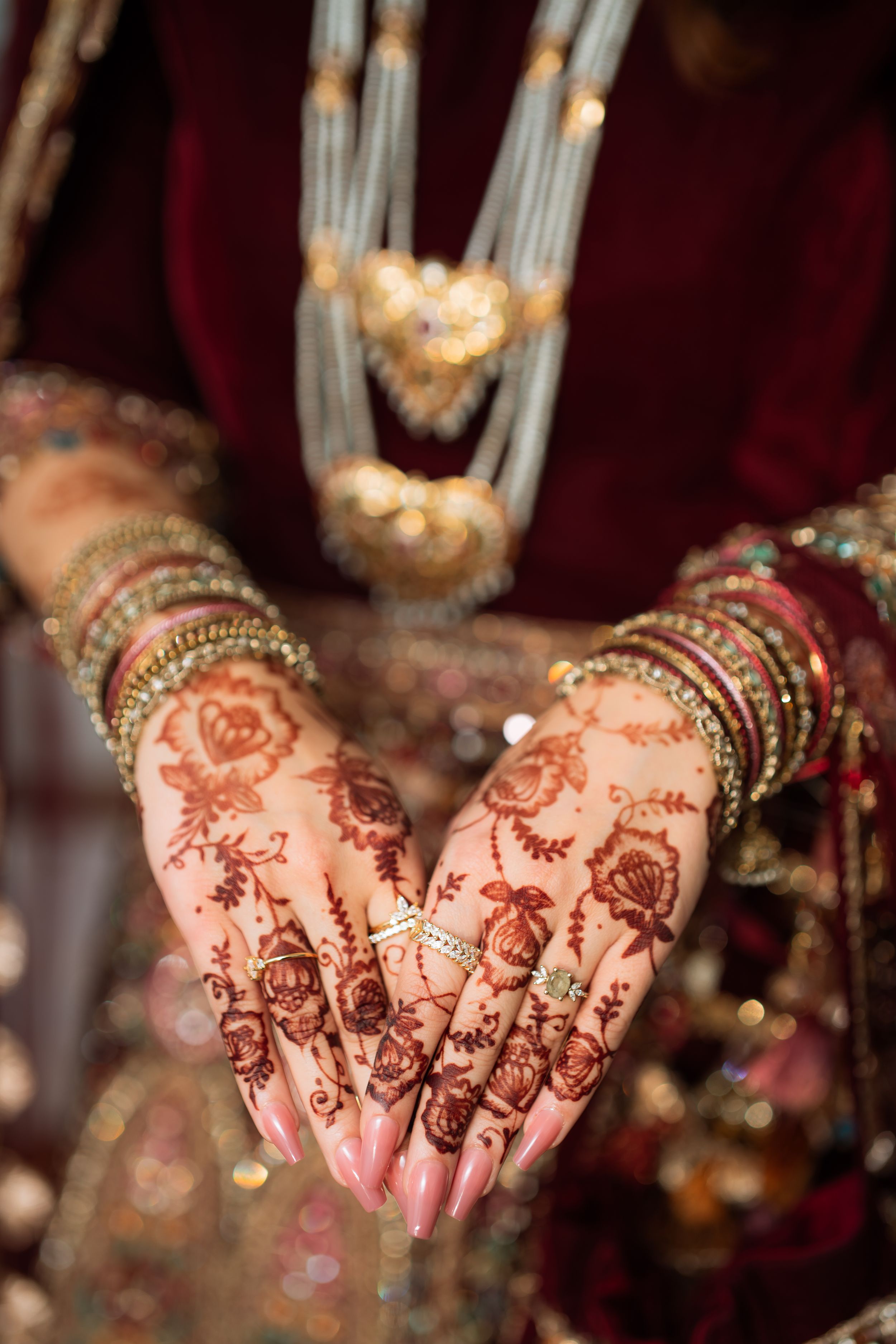 Traditional Indian bridal henna designs displayed on hands with intricate floral and paisley patterns in mehndi art.