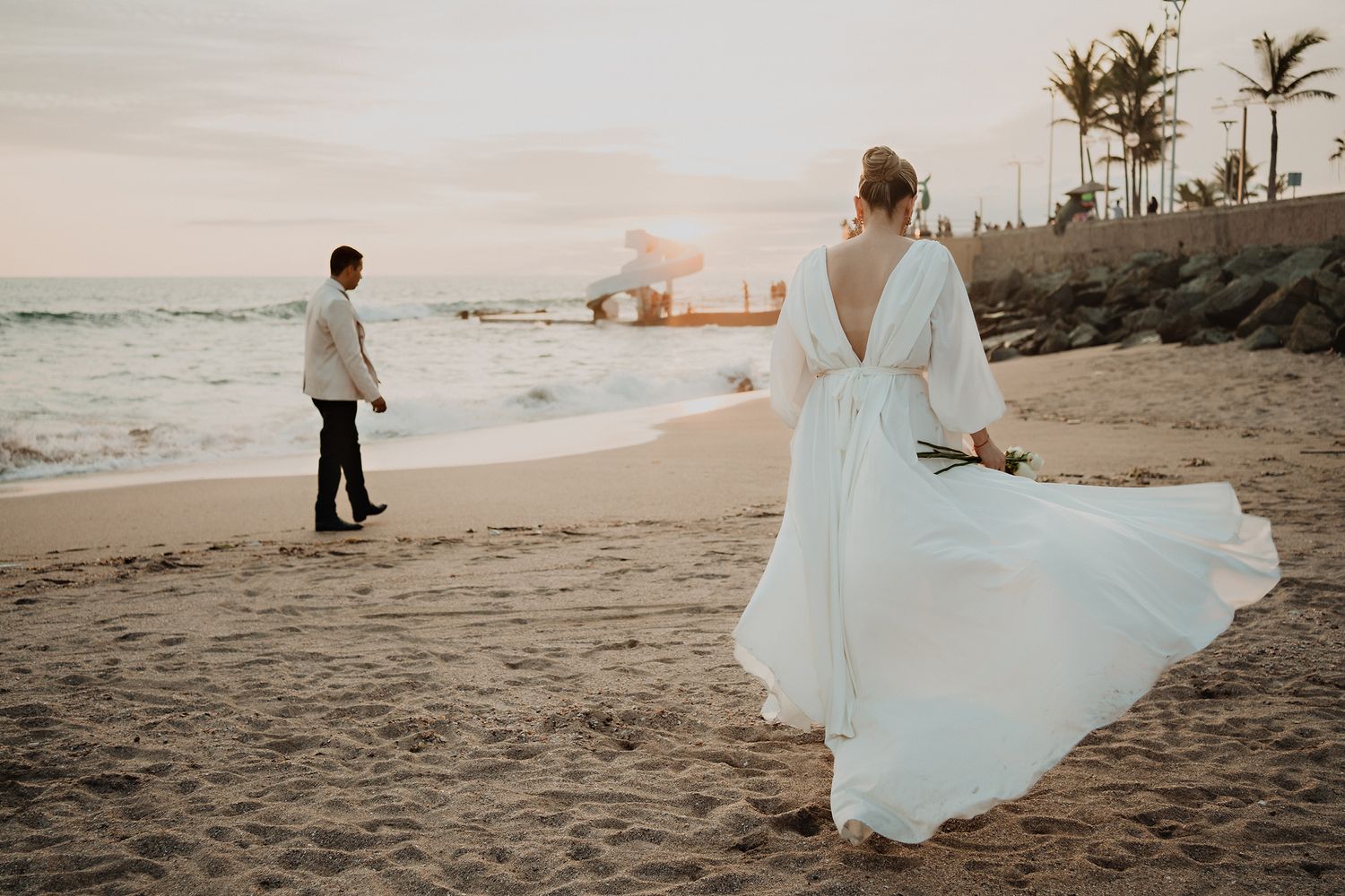 Novia caminando hacia el novio durante una boda en la playa de Mazatlán al atardecer