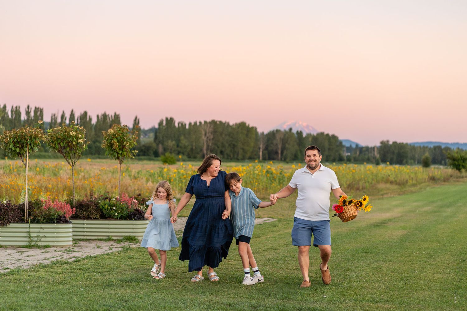 Family walking in flower field at sunset.