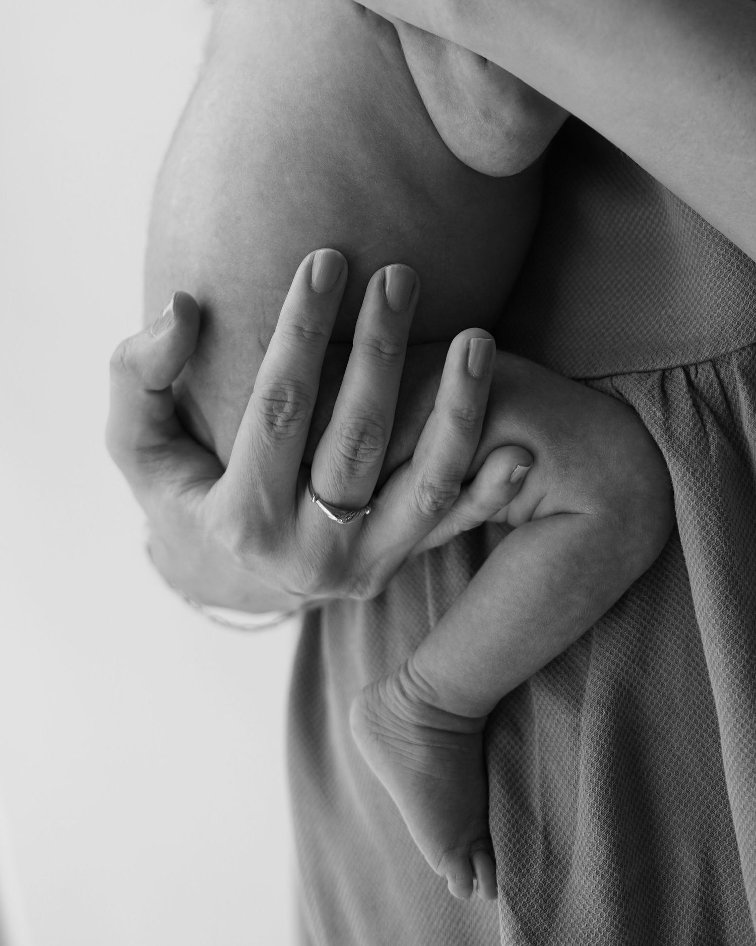 Lifestyle newborn session mother holding baby in natural light