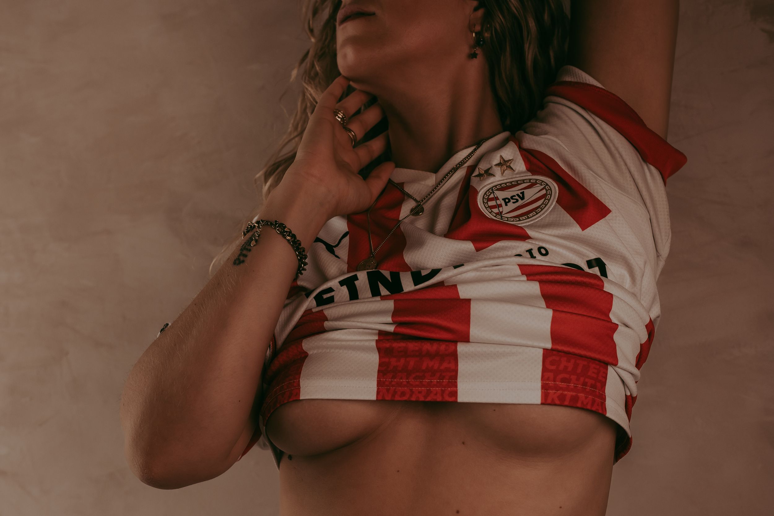 Vrouw draagt een PSV shirt met een beetje kijk op haar borsten