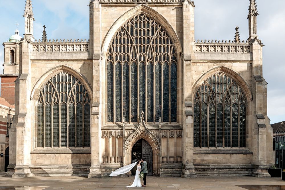 Relaxed wedding portrait of couple in front of a historic church.
