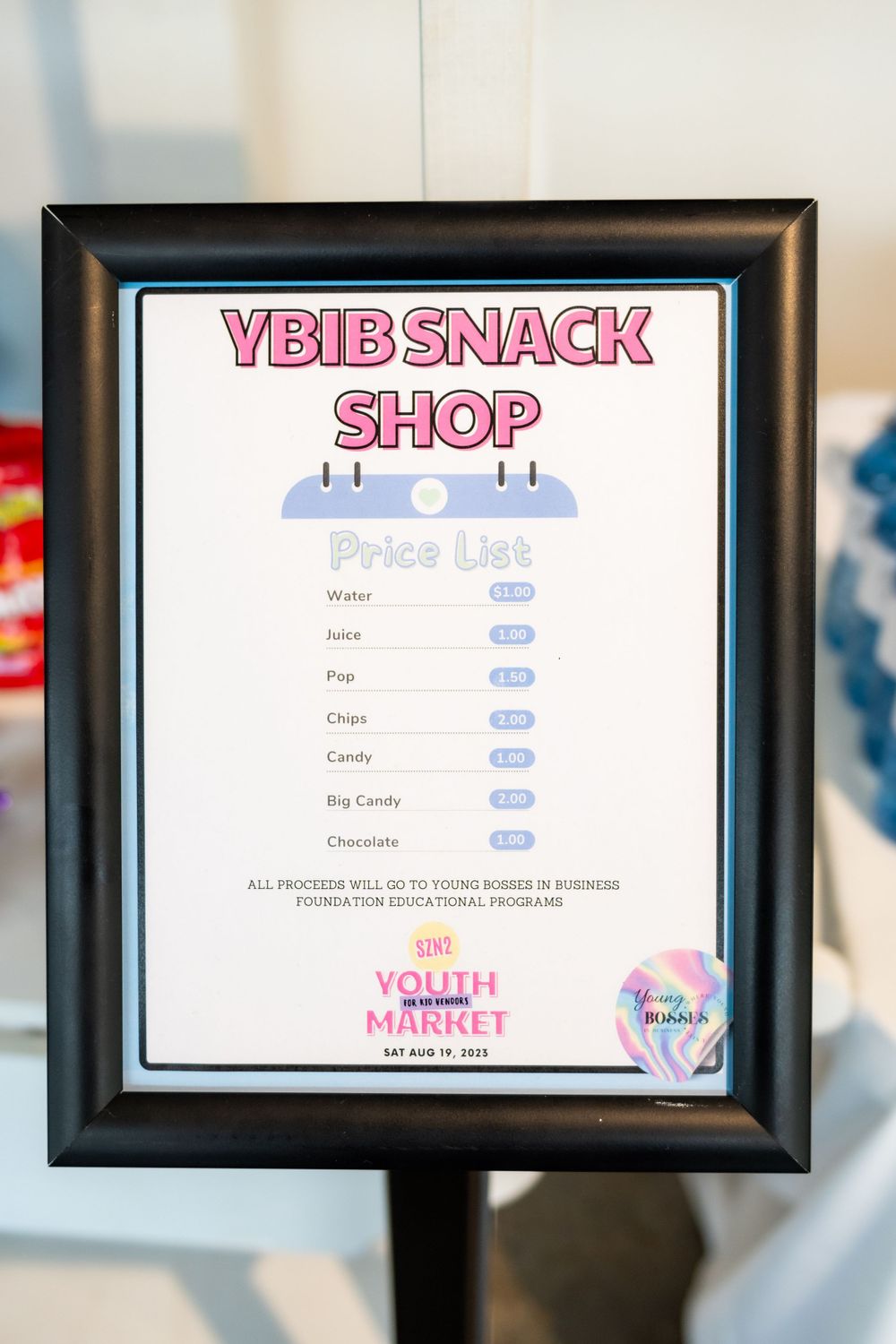Framed menu board displaying YBB Snack Shop price list.