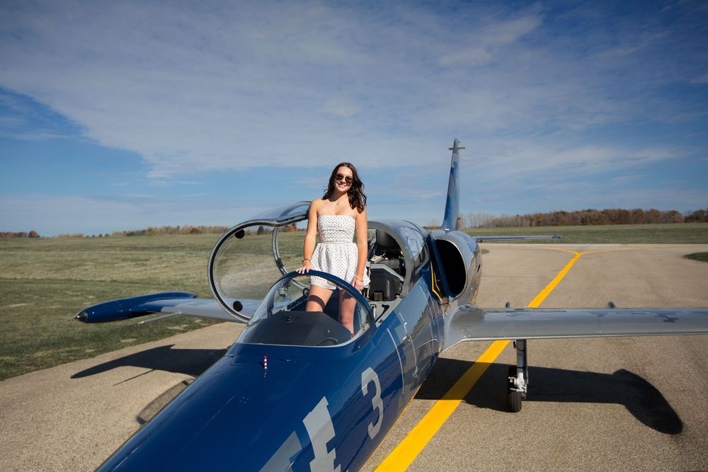 Modern high school senior portrait with jet plane in Howell Michigan; senior aviation photos by Brighton, MI photographer