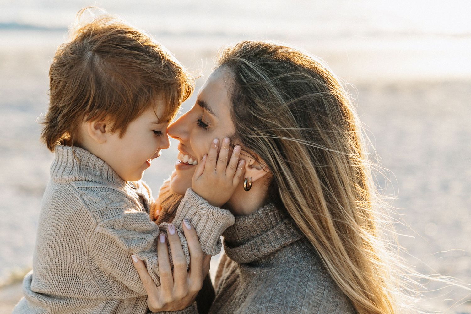 son with hands on mother's face